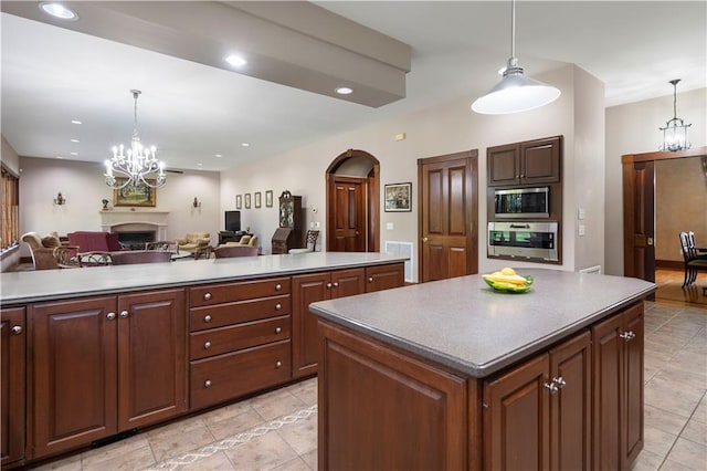 22450 Elderberry Ln, Bush, LA 70431 - kitchen featuring oven, stainless steel microwave, a fireplace, a chandelier, and a center island