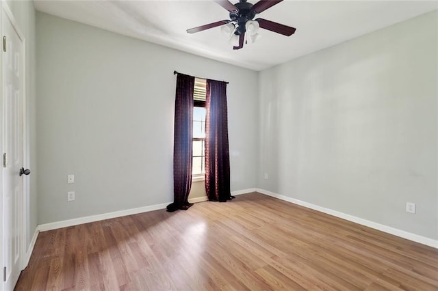 unfurnished room featuring a ceiling fan, wood finished floors, and baseboards