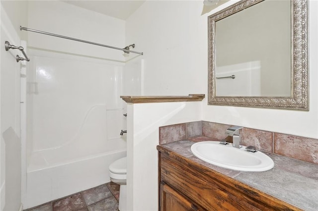 bathroom featuring toilet, vanity, and  shower combination