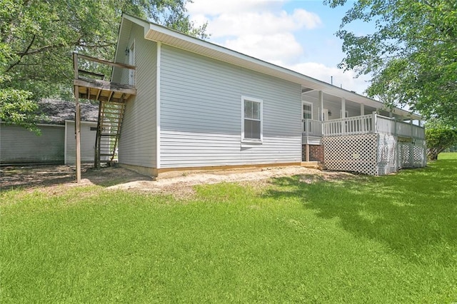 rear view of property with a lawn and a balcony