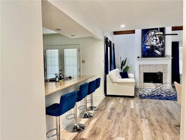 1500 W Esplanade Ave Unit 3-B, Kenner, LA 70065 - living area with wood finished floors, baseboards, a tiled fireplace, and a textured ceiling