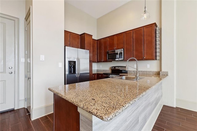 1201 Canal St Unit 521, New Orleans, LA 70112 - kitchen with appliances with stainless steel finishes, a sink, a peninsula, wood finish floors, and light stone countertops