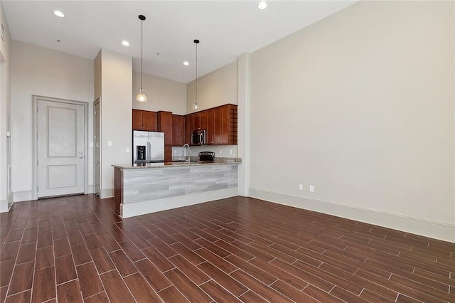 1201 Canal St Unit 521, New Orleans, LA 70112 - kitchen with appliances with stainless steel finishes, a sink, baseboards, a peninsula, and a towering ceiling