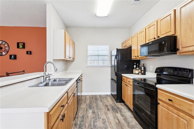 1902 Huey P Long Ave, Gretna, LA 70053 - kitchen with black appliances, a sink, wood finished floors, light brown cabinets, and light countertops