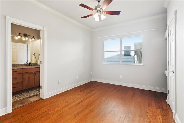 26 Camellia Dr, Covington, LA 70433 - unfurnished bedroom with wood finished floors, crown molding, baseboards, a ceiling fan, and connected bathroom
