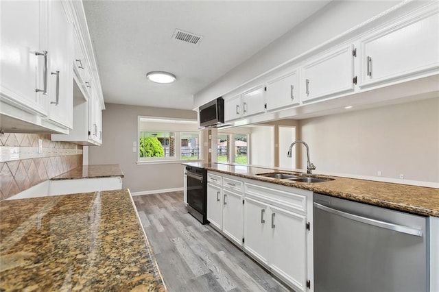 7511 Fieldston Rd, New Orleans, LA 70126 - kitchen with stainless steel dishwasher, a sink, white cabinetry, and tasteful backsplash