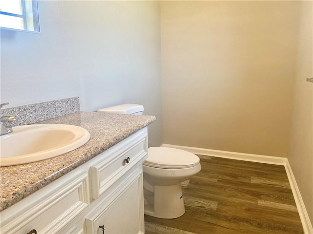 7511 Fieldston Rd, New Orleans, LA 70126 - half bath featuring vanity, toilet, wood finished floors, and baseboards