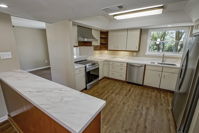 5831 Durbridge Dr, New Orleans, LA 70131 - kitchen featuring appliances with stainless steel finishes, a sink, wall chimney range hood, wood finished floors, and open shelves