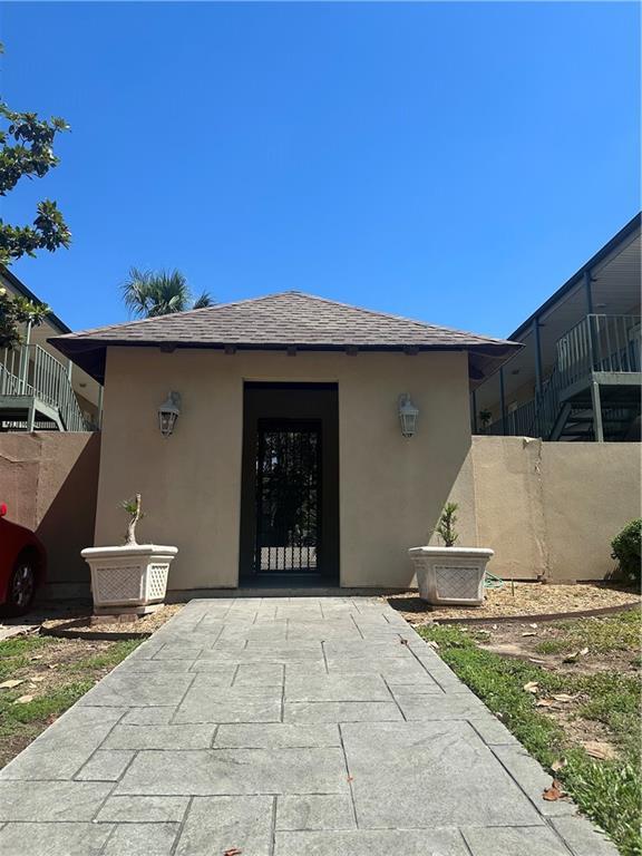3725 Marion St Unit 5, Metairie, LA 70002 - view of exterior entry featuring stucco siding and roof with shingles