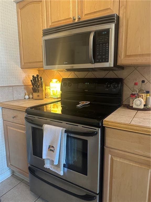 3725 Marion St Unit 5, Metairie, LA 70002 - kitchen with appliances with stainless steel finishes, decorative backsplash, tile countertops, light tile patterned floors, and light brown cabinets