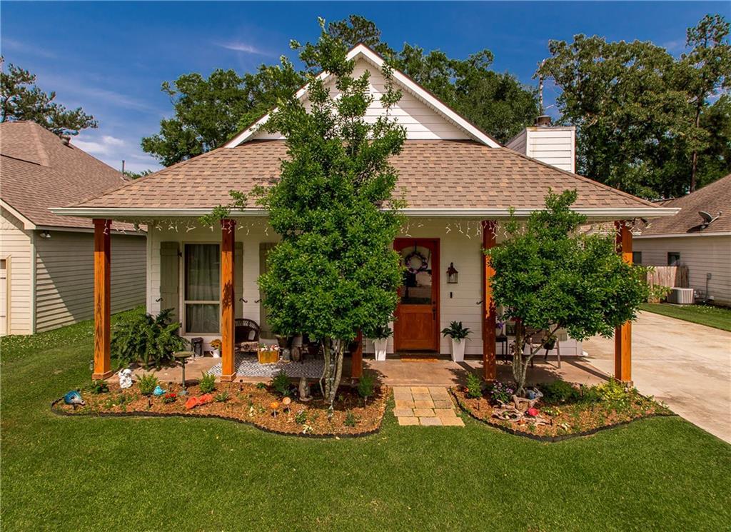 810 St Joseph Dr, Ponchatoula, LA 70454 - view of front facade with a shingled roof, covered porch, a front yard, and a chimney
