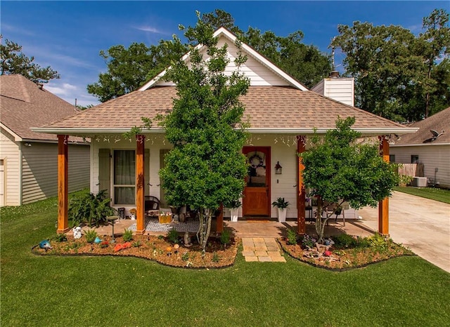 810 St Joseph Dr, Ponchatoula, LA 70454 - view of front facade with a shingled roof, covered porch, a front yard, and a chimney