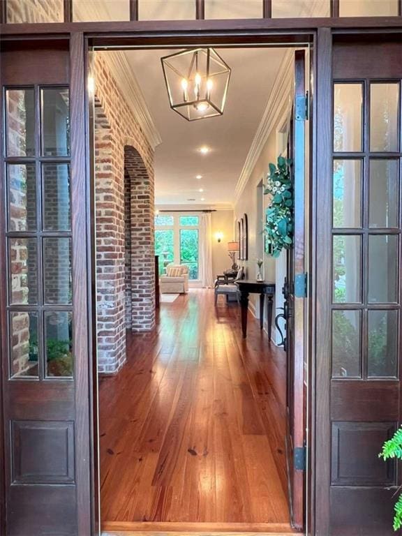 7 Spanish Moss Ct, Mandeville, LA 70471 - hall featuring crown molding, wood finished floors, and a chandelier
