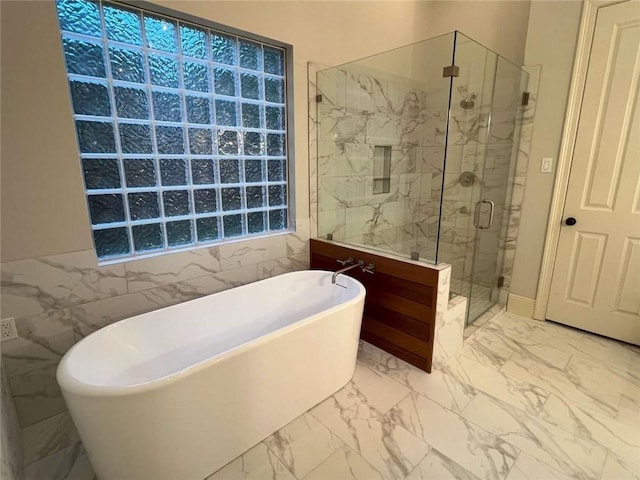 7 Spanish Moss Ct, Mandeville, LA 70471 - bathroom with marble look tile flooring, a shower stall, a freestanding tub, and tile walls