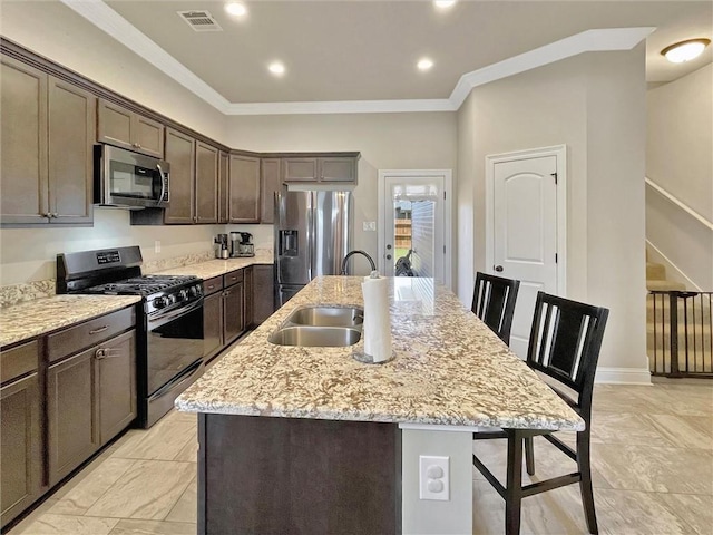 629 High Ridge Loop, Slidell, LA 70458 - kitchen with stainless steel appliances, a kitchen island with sink, a kitchen breakfast bar, a sink, and dark brown cabinetry