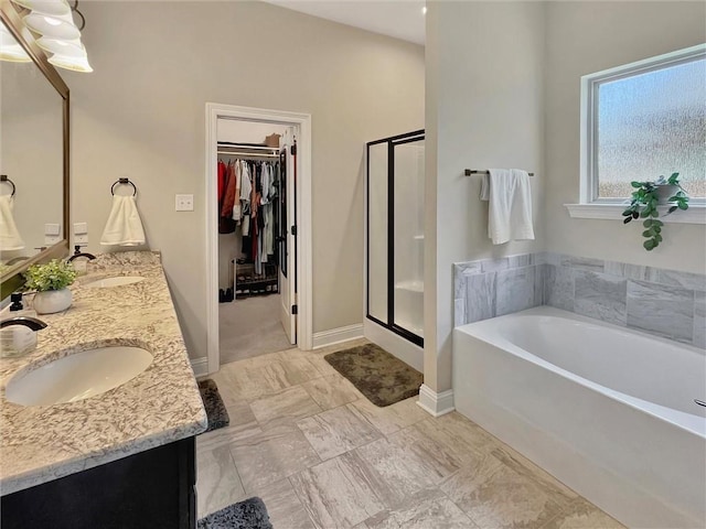 629 High Ridge Loop, Slidell, LA 70458 - full bathroom featuring a garden tub, a stall shower, a spacious closet, double vanity, and baseboards