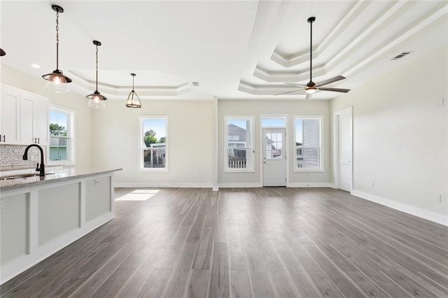 5128 Cunningham Ct, New Orleans, LA 70126 - unfurnished living room featuring a tray ceiling, a sink, ceiling fan, wood finished floors, and crown molding