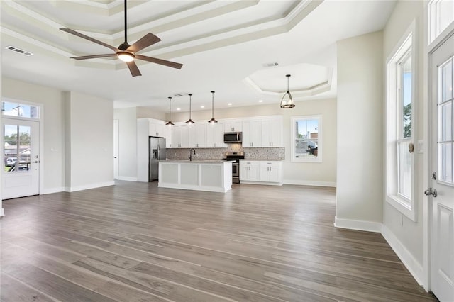 5128 Cunningham Ct, New Orleans, LA 70126 - unfurnished living room featuring a tray ceiling, baseboards, dark wood-style flooring, a sink, and ornamental molding