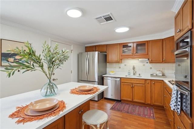 4 Virginia Ct, New Orleans, LA 70124 - kitchen featuring a sink, appliances with stainless steel finishes, light countertops, wood finished floors, and brown cabinets