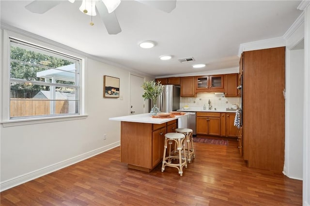 4 Virginia Ct, New Orleans, LA 70124 - kitchen featuring brown cabinets, a kitchen island, stainless steel appliances, a ceiling fan, and dark wood-style floors