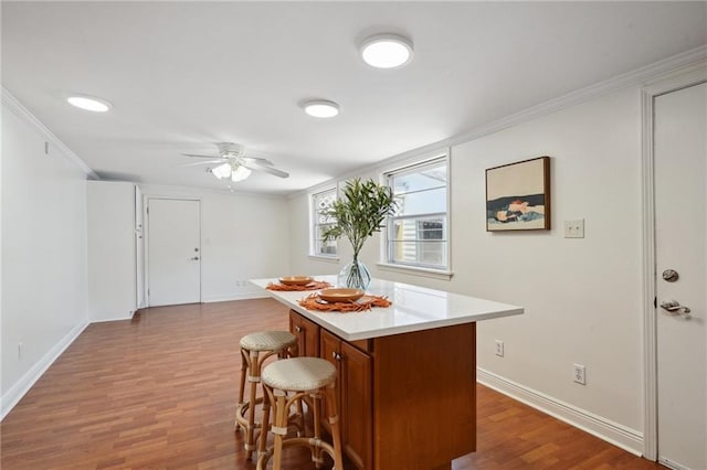 4 Virginia Ct, New Orleans, LA 70124 - kitchen featuring a breakfast bar area, ceiling fan, a kitchen island, wood finished floors, and brown cabinets