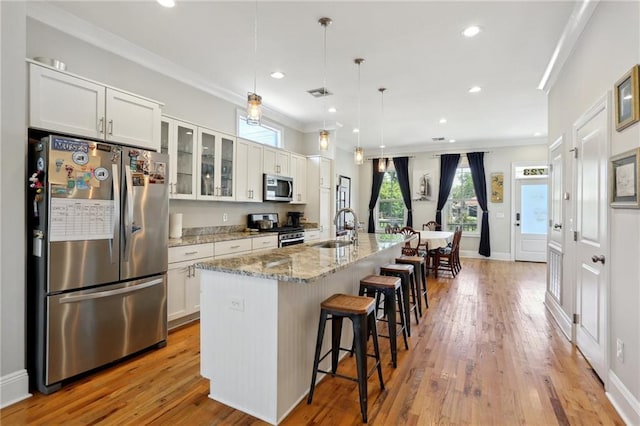 1723 N Broad St, New Orleans, LA 70119 - kitchen featuring stainless steel appliances, a sink, a breakfast bar area, an island with sink, and ornamental molding