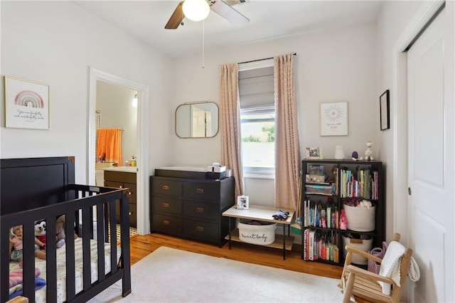 1723 N Broad St, New Orleans, LA 70119 - bedroom with light wood-style flooring, a crib, a closet, ceiling fan, and connected bathroom