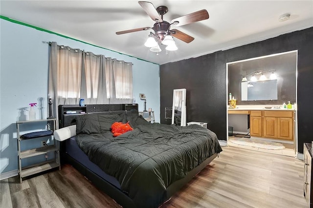 2713 Legend St, Meraux, LA 70075 - bedroom with light wood-style floors, a ceiling fan, a sink, baseboards, and ensuite bath