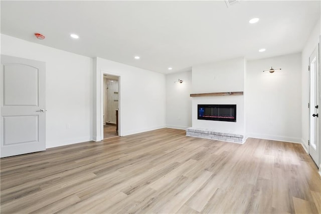 4412 Camel St, Metairie, LA 70001 - unfurnished living room featuring light wood-type flooring, a brick fireplace, recessed lighting, and baseboards