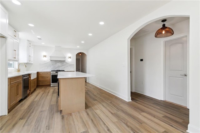 4412 Camel St, Metairie, LA 70001 - kitchen with appliances with stainless steel finishes, custom exhaust hood, light countertops, light wood finished floors, and recessed lighting