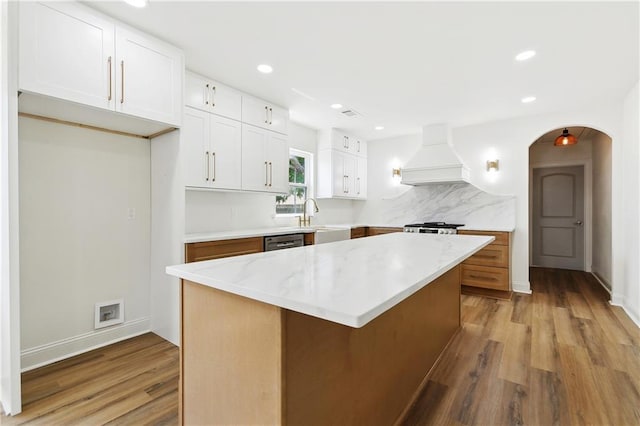 4412 Camel St, Metairie, LA 70001 - kitchen featuring premium range hood, light wood finished floors, white cabinets, a center island, and recessed lighting