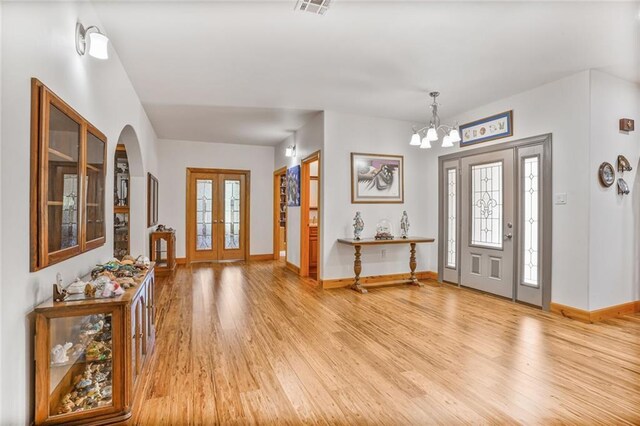 25506 Cardinal Ct, Bush, LA 70431 - foyer featuring light wood finished floors, a chandelier, baseboards, and arched walkways