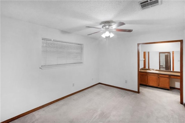 154 Oakwood Dr, Mandeville, LA 70448 - unfurnished bedroom featuring a sink, light colored carpet, baseboards, a textured ceiling, and ceiling fan