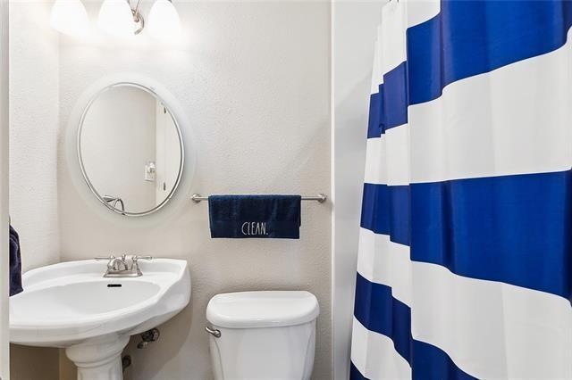 313 Celeste Ave, River Ridge, LA 70123 - bathroom with toilet, a sink, and a shower with shower curtain