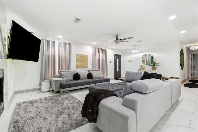 living room with light marble finish flooring, ceiling fan, and recessed lighting