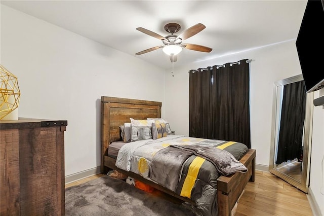 bedroom featuring light wood-type flooring, ceiling fan, and baseboards