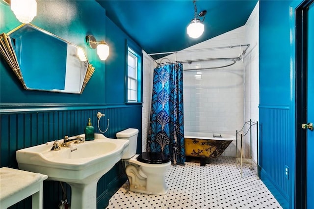 613 Pacific Ave, New Orleans, LA 70114 - bathroom featuring toilet, a wainscoted wall, shower / tub combo, and a sink