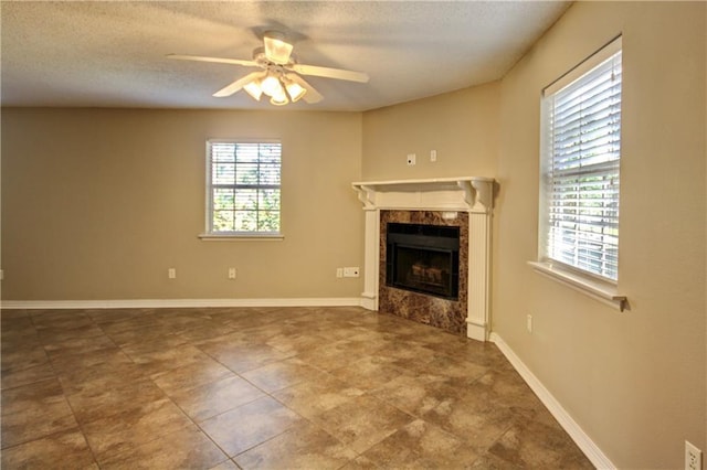 717 Heavens Dr Unit 4, Mandeville, LA 70471 - unfurnished living room featuring a high end fireplace, ceiling fan, a textured ceiling, and baseboards