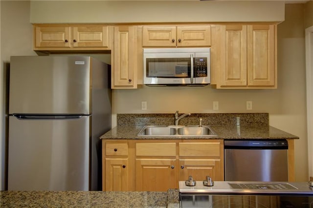 717 Heavens Dr Unit 4, Mandeville, LA 70471 - kitchen featuring appliances with stainless steel finishes, a sink, light brown cabinets, and dark stone counters