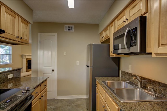 717 Heavens Dr Unit 4, Mandeville, LA 70471 - kitchen featuring stainless steel appliances, a sink, baseboards, light brown cabinets, and light tile patterned flooring