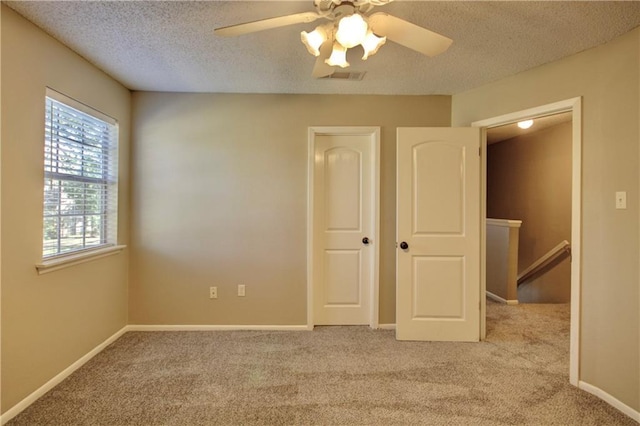 717 Heavens Dr Unit 4, Mandeville, LA 70471 - unfurnished bedroom featuring light carpet, a textured ceiling, ceiling fan, and baseboards