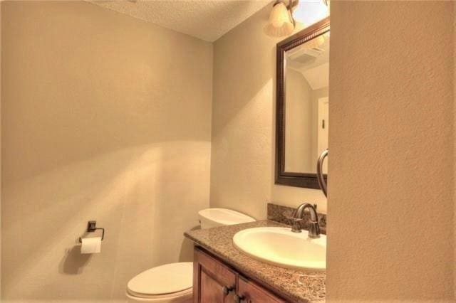 717 Heavens Dr Unit 4, Mandeville, LA 70471 - bathroom with a textured ceiling, toilet, and vanity