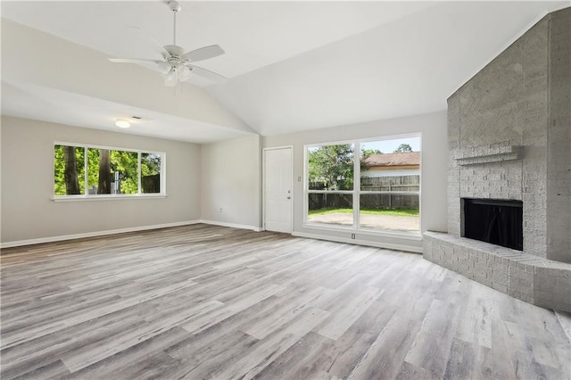 301 Holmes Dr, Slidell, LA 70460 - unfurnished living room with lofted ceiling, wood finished floors, a brick fireplace, ceiling fan, and baseboards