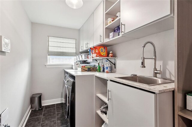 3928 Uri St, Metairie, LA 70002 - washroom with cabinet space, separate washer and dryer, dark tile patterned flooring, and baseboards