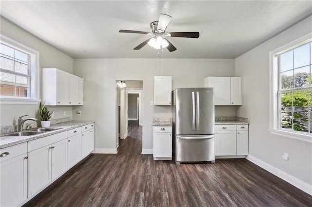 1816 Congress St, New Orleans, LA 70117 - kitchen with freestanding refrigerator, a sink, dark wood-style floors, and white cabinetry