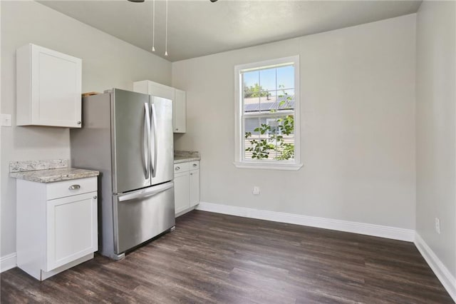1816 Congress St, New Orleans, LA 70117 - kitchen with freestanding refrigerator, dark wood-style floors, baseboards, and white cabinets