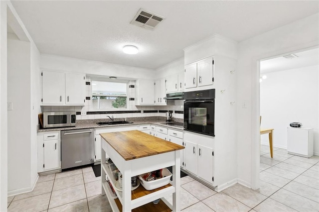 242 Willow Dr, Gretna, LA 70053 - kitchen featuring black appliances, a sink, open shelves, tasteful backsplash, and white cabinets