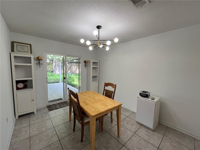 242 Willow Dr, Gretna, LA 70053 - dining space featuring a chandelier, baseboards, and a textured ceiling
