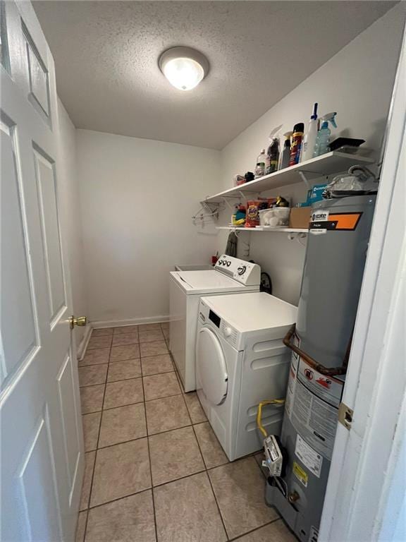 242 Willow Dr, Gretna, LA 70053 - clothes washing area with washer and dryer, a textured ceiling, light tile patterned floors, and water heater