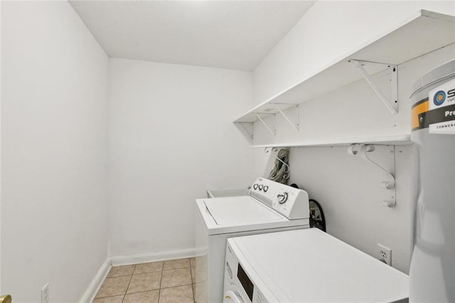 242 Willow Dr, Gretna, LA 70053 - laundry area with washer and clothes dryer, baseboards, light tile patterned flooring, and water heater